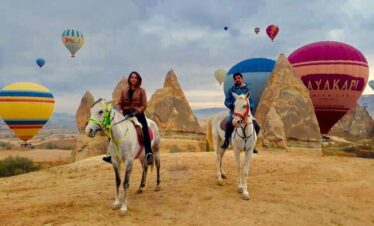 Couple enjoying a love-filled horse ride through the breathtaking valleys of Cappadocia