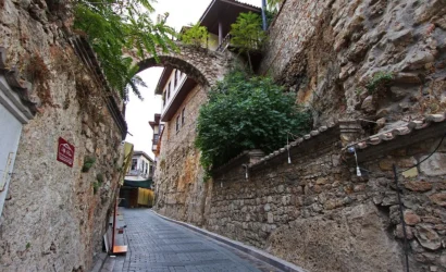 Scenic view of Antalya Roman Harbour with tour boats, historic stone walls, and the turquoise Mediterranean Sea