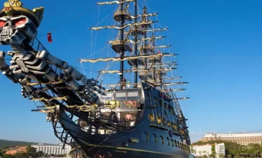 Pirate boat returning to Kemer harbor after Antalya cruise at sunset